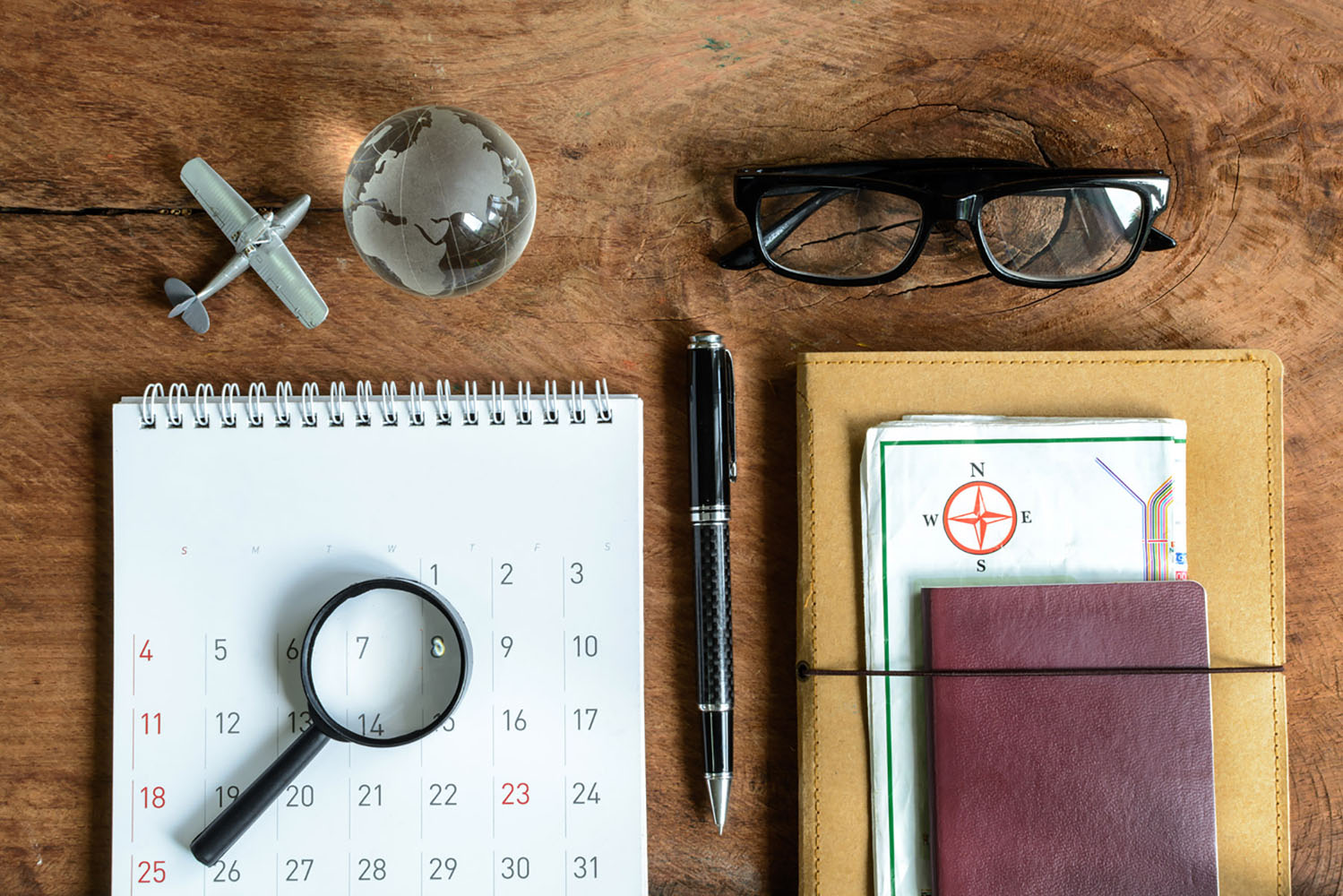 A travel calendar, glasses, a pen, and other important items for travel