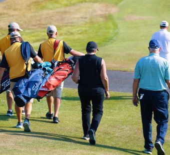 golfers & caddies walking to next hole