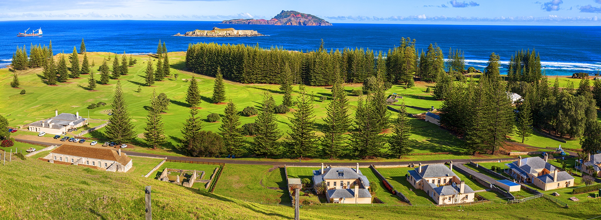 seaside homes set in green grass along blue water shoreline