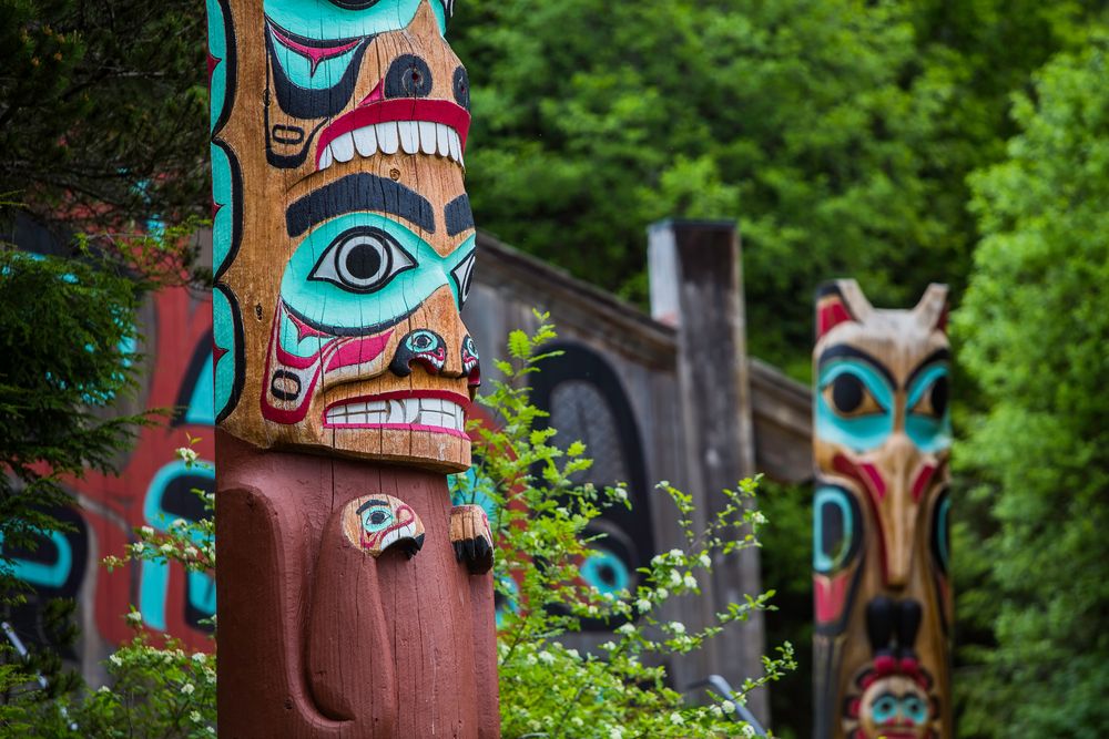 Colorful Native totem poles surrounded by forest in Ketchikan, Alaska.