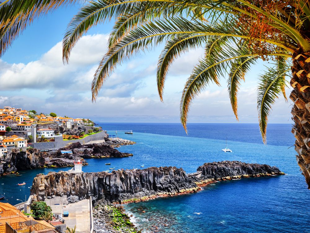 Oceanfront cliffs and seaside villages along the coast of Madeira, Portugal.